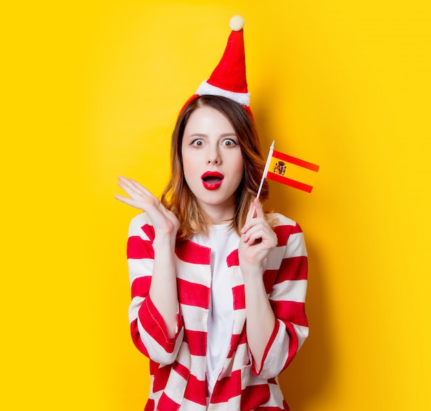 donna in cappello di Babbo Natale con la bandiera della Spagna