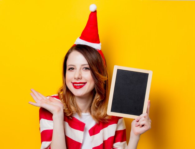 donna in cappello di Babbo Natale con la lavagna