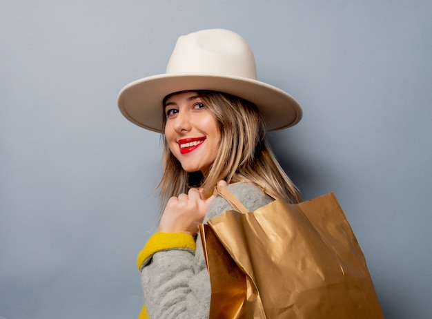 Donna in cappotto con la borsa della spesa