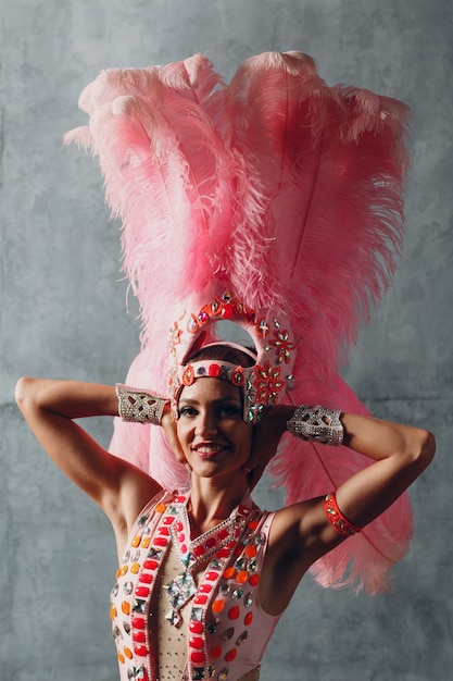 Donna in costume da samba o lambada con piumaggio di piume rosa.