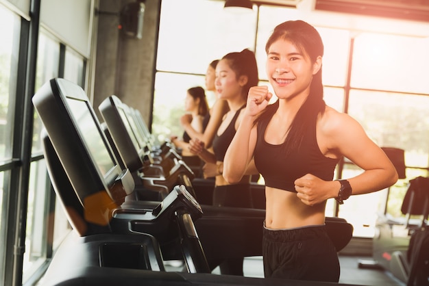 Donna in esecuzione o fare jogging sul tapis roulant nella moderna palestra sportiva. esercizio e concetto di sport.