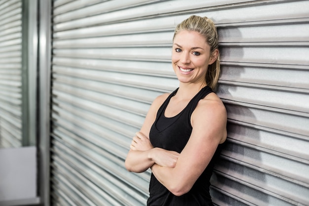 Donna in forma con braccio incrociato in palestra di crossfit