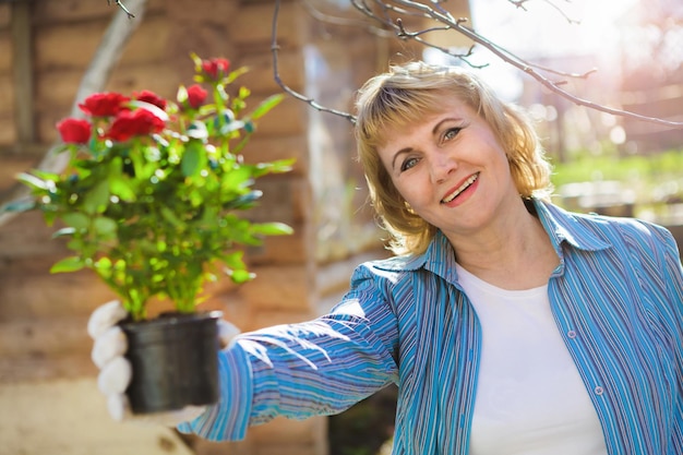 Donna in giardino che prepara piante da piantare nel terreno