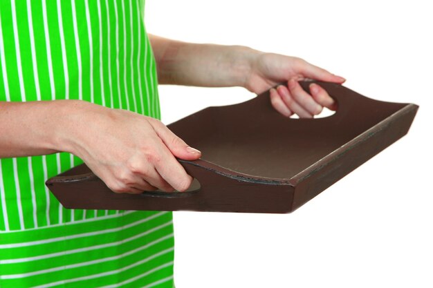 Donna in grembiule verde che tiene vassoio di legno isolato su bianco