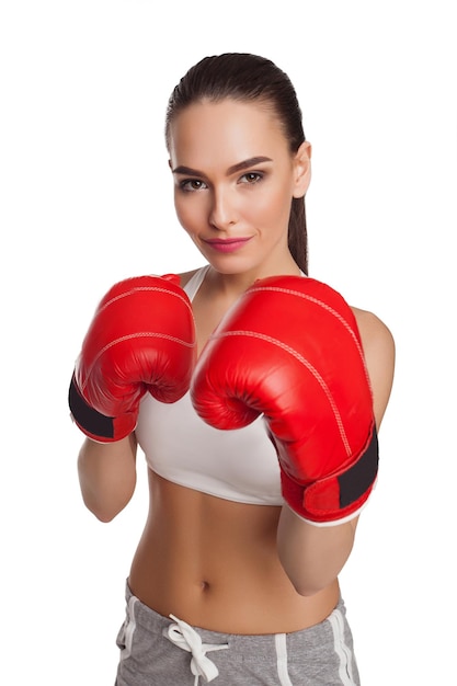 Donna in guantoni da boxe e abbigliamento sportivo su sfondo bianco