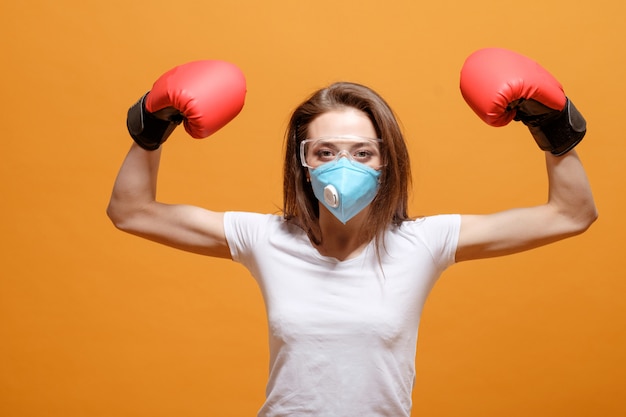 Donna in guantoni da boxe, quarantena domestica, pandemia di coronavirus, battaglia di combattimento con virus