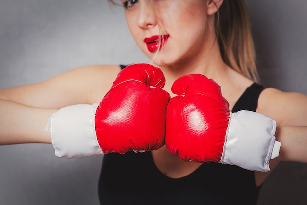 donna in guantoni da boxe su sfondo grigio