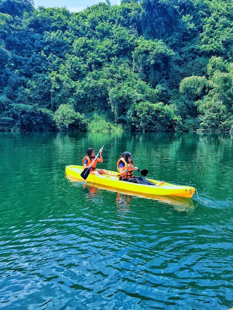 Donna in kayak sul fiume nella foresta