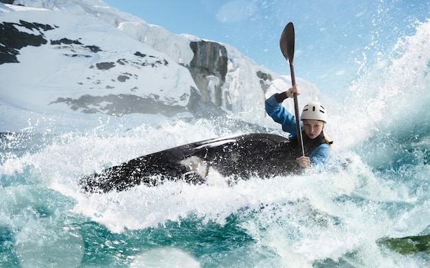 Donna in kayak vele su un fiume di montagna Whitewater kayak kayak estremo