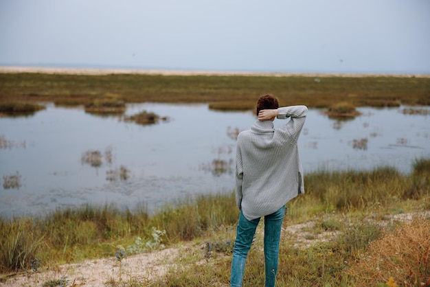 Donna in maglione sul paesaggio della passeggiata nella natura
