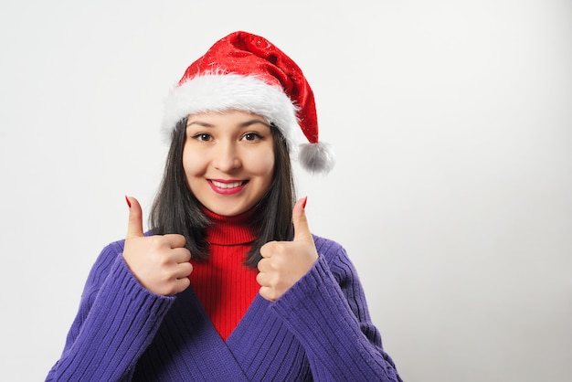 Donna in maglione viola e cappello di natale su priorità bassa bianca