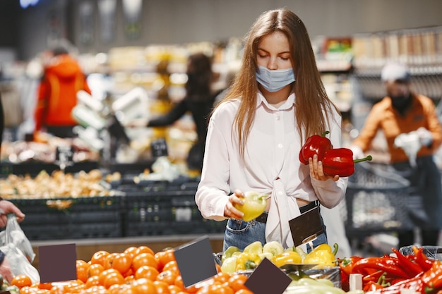 Donna in mascherina protettiva medica in un supermercato.