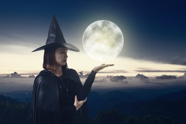 Donna in nero spaventoso strega costume di halloween con chiaro di luna