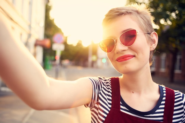 Donna in occhiali da sole con posa romantica all'aperto di capelli corti