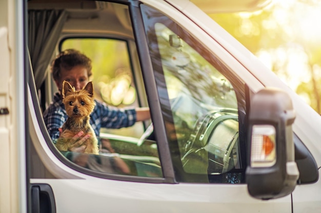 Donna in pensione caucasica che viaggia con il cane nel camper RV Van Australian Silky Terrier in tour Concept Destinazione per le vacanze estive