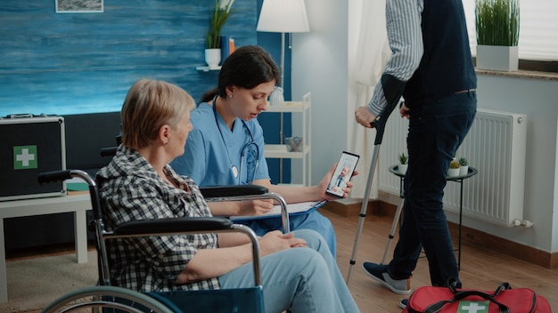 Donna in pensione e infermiera che parlano con il medico in videochiamata