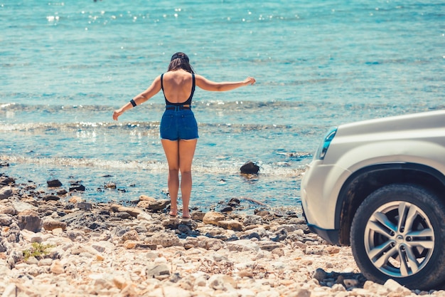 Donna in piedi al concetto di viaggio in auto spiaggia