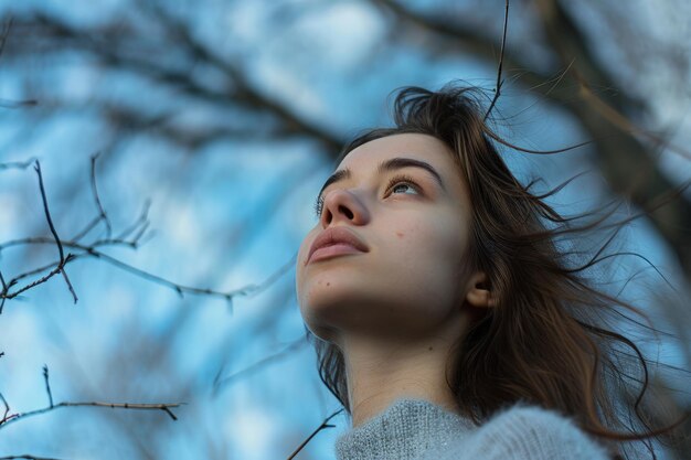 Donna in piedi davanti all'albero che guarda in alto