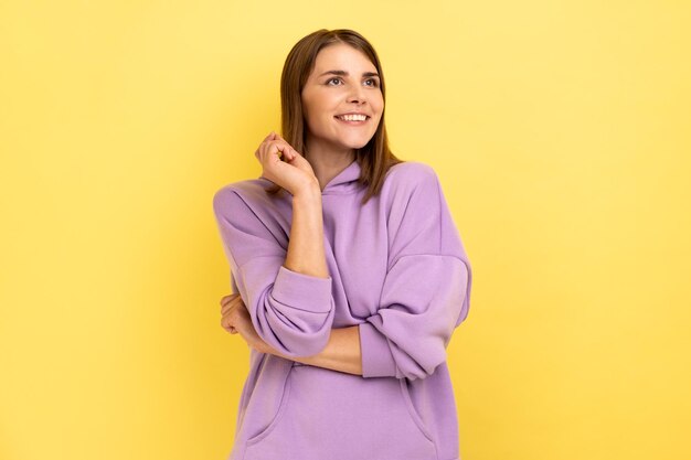 Donna in piedi e sognando che desidera l'amore distogliendo lo sguardo con un sorriso a trentadue denti