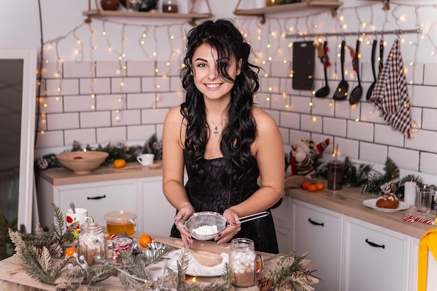 Donna in piedi in cucina che cucina la cena delle vacanze