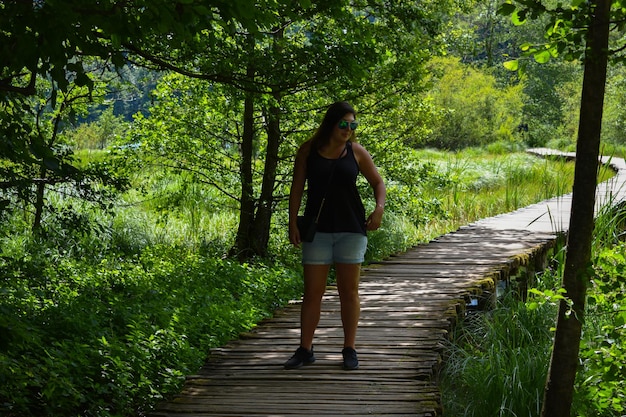 Donna in piedi sul marciapiede nella foresta