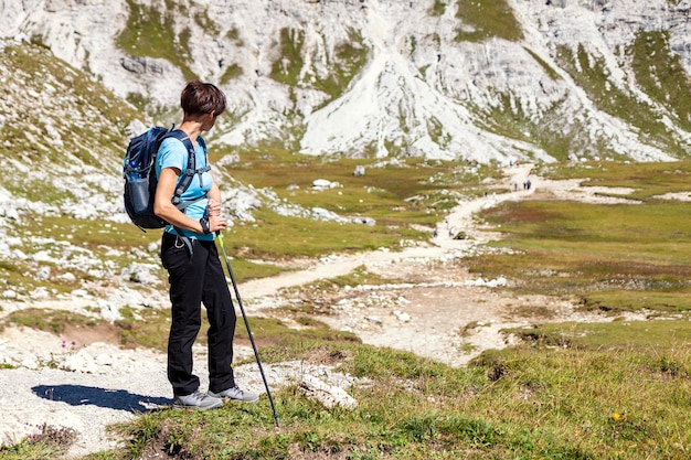 Donna in piedi sul sentiero escursionistico nel paesaggio panoramico delle montagne