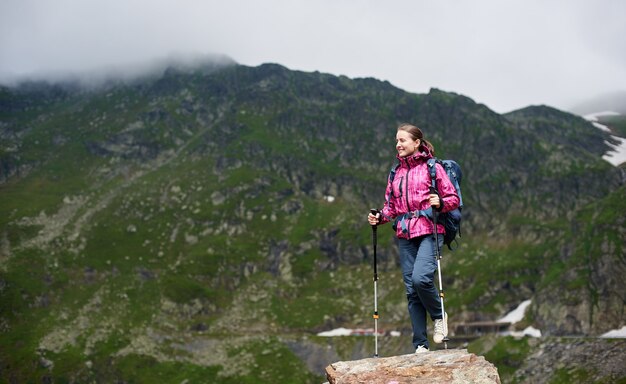 Donna in piedi sulla cima di una collina in montagna