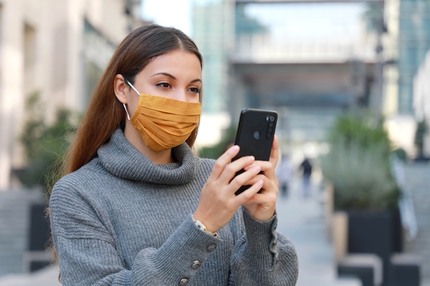 Donna in piedi sulla strada in maschera protettiva e messaggistica