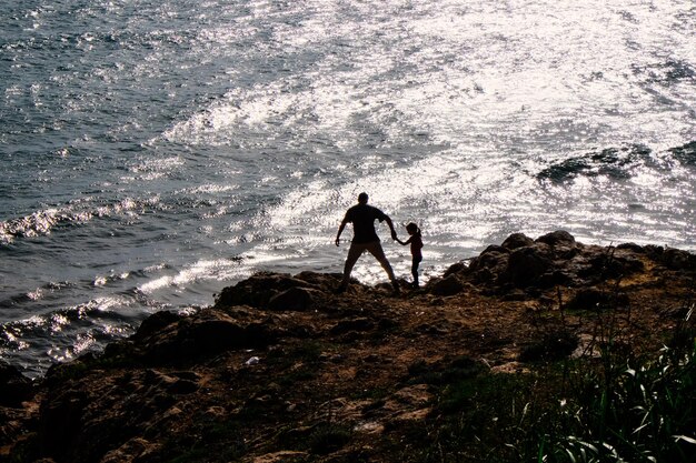 Donna in piedi sulle rocce in riva al mare