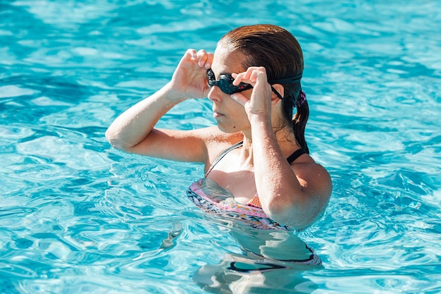 Donna in piscina che indossa gli occhiali da nuoto