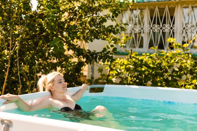 donna in piscina nel giardino di una casa privata