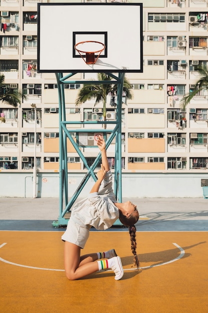 donna in posa sul campo da basket nella città di Hong Kong