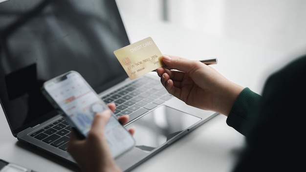 Donna in possesso di una carta di credito usa una carta di credito per pagare beni e servizi online il concetto di utilizzare una carta di credito per lo shopping online ordinando beni e servizi sul sito Web