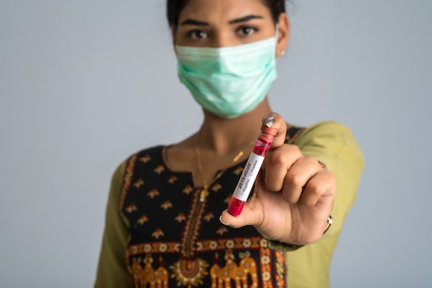 Donna in possesso di una provetta con campione di sangue per coronavirus o analisi 2019-nCoV.