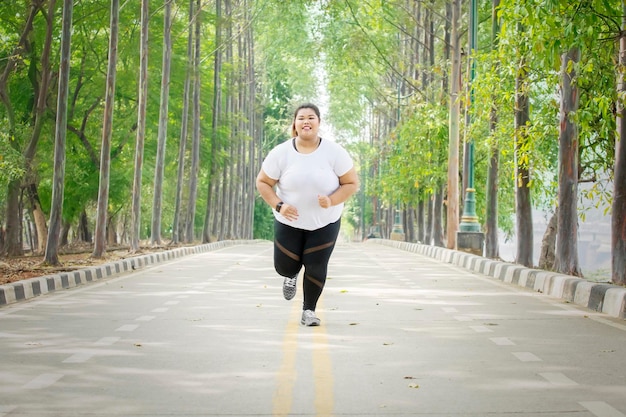 Donna in sovrappeso che fa jogging al parco