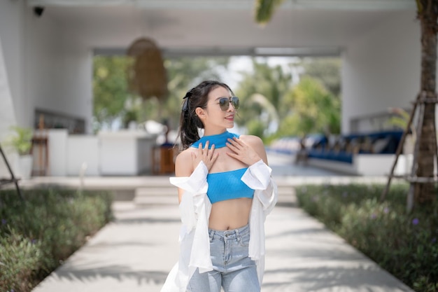 Donna in top blu e jeans che camminano in hotel resort tropicale