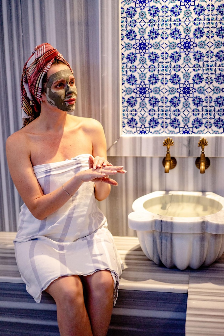 Foto donna in torre che fa la maschera facciale in bagno foto