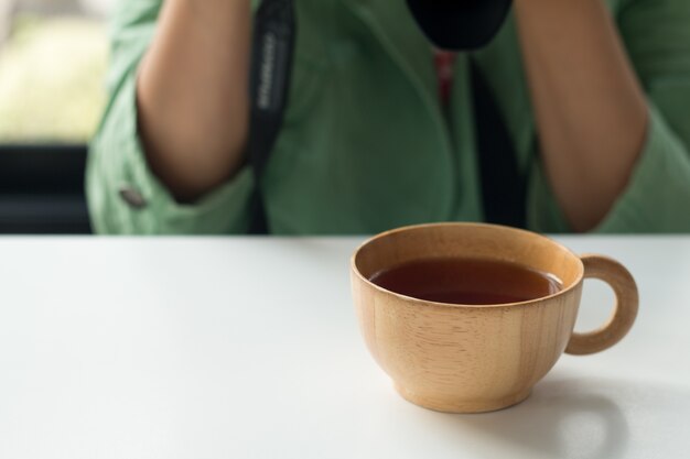 Donna in tuta verde con una tazza di tè caldo