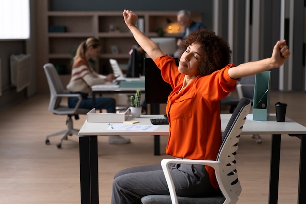 Donna in ufficio che si allunga durante una giornata lavorativa