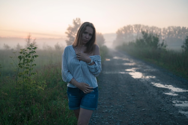 Donna in un campo con nebbia nebbiosa