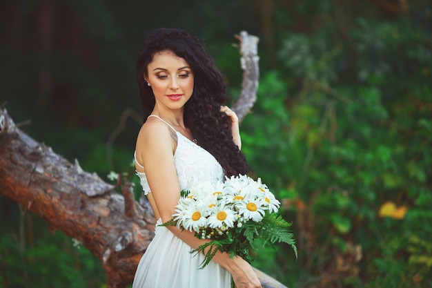 Donna in un vestito bianco che posa in un campo