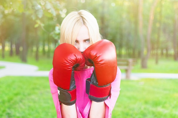 Donna in un vestito che indossa i guantoni da boxe