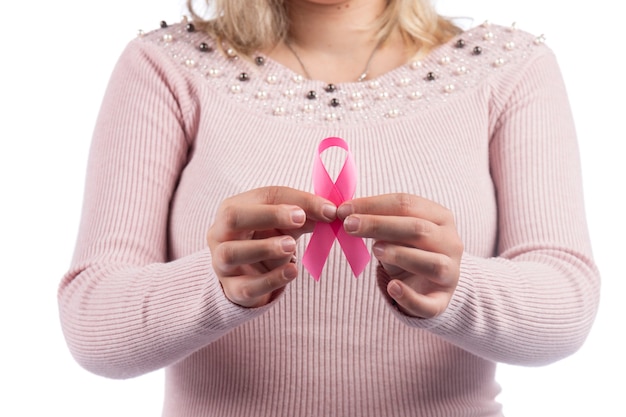 Donna in un vestito rosa che tiene il nastro del cancro al seno