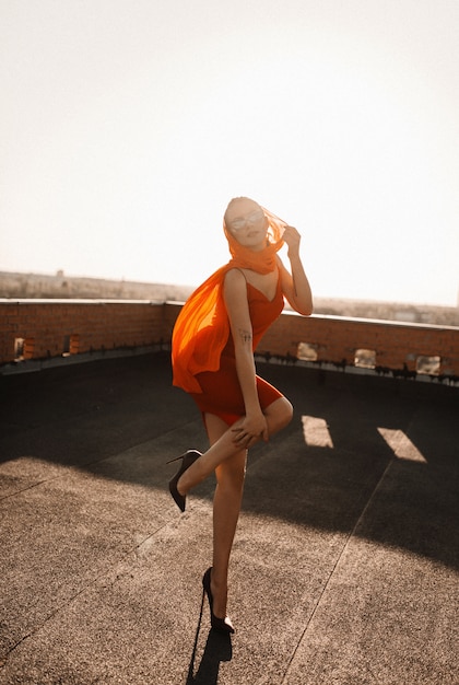 donna in un vestito rosso al tramonto