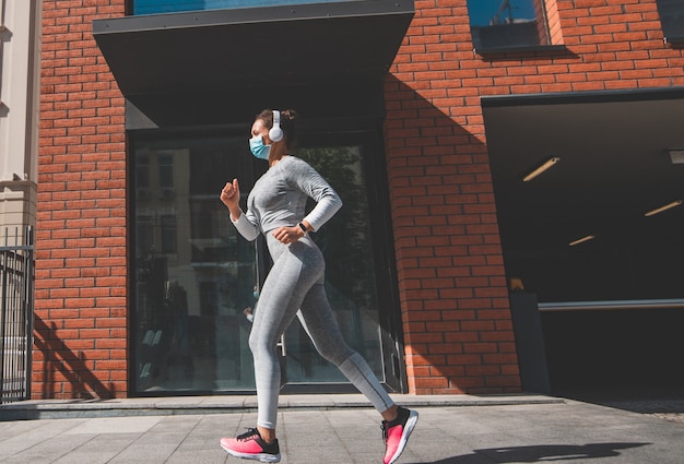 Donna in una maschera medica che corre per la strada