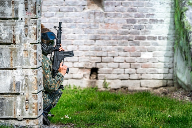 Donna in uniforme con una pistola durante l'addestramento militare di paintball