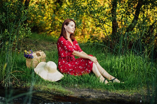 Donna in vestito rosso che si gode la pratica dell'ecoterapia della terapia della natura della natura di essere nella natura per aumentare