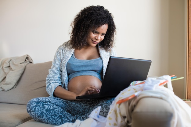 Donna incinta africana che acquista online per il suo bambino