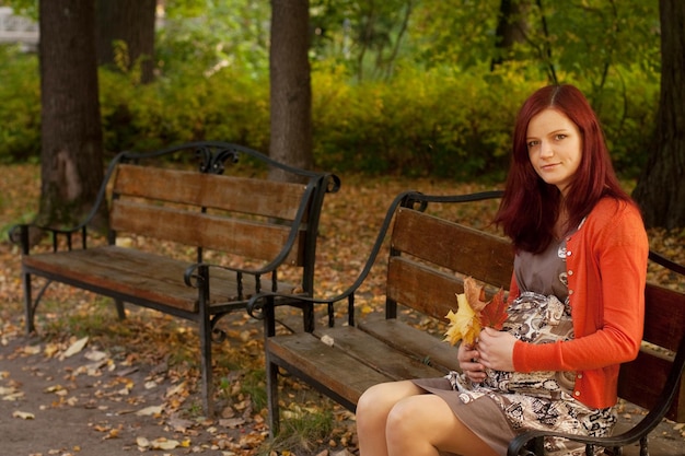 Donna incinta che cammina nel parco di autunno