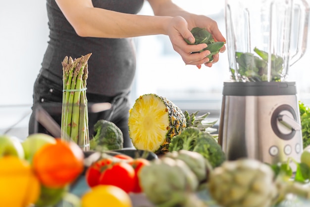 Donna incinta che cucina frullato sano